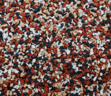 Seminole Close-up of a surface covered with small, irregularly shaped granules in red, black, white, and tan colors, creating a speckled, textured pattern.