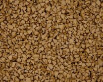 Close-up view of a surface covered with small, irregularly shaped brown granules or particles, resembling pieces of dry, crushed material tightly packed together.