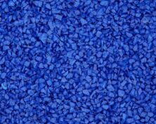 Close-up of a textured surface covered with small, irregular blue rubber granules, often used for playgrounds or athletic tracks.