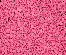 Close-up of many small pink rubber granules or pellets, forming a dense, textured surface.