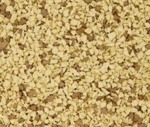Sandalwood A close-up of a textured surface covered with small, irregularly shaped beige and light brown granules, resembling instant coffee or cereal flakes.