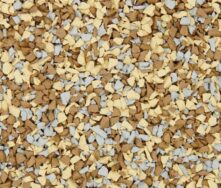 A close-up of small, irregularly shaped granules in tan, light yellow, and light gray colors, densely packed together and covering the entire frame.