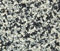 Close-up of a textured surface with small, irregular black, white, and gray granules, resembling rubber or gravel pieces, densely packed together.