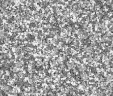 A close-up of a textured gray and white speckled surface, resembling small pebbles or granules tightly packed together, creating a rough, uneven pattern.